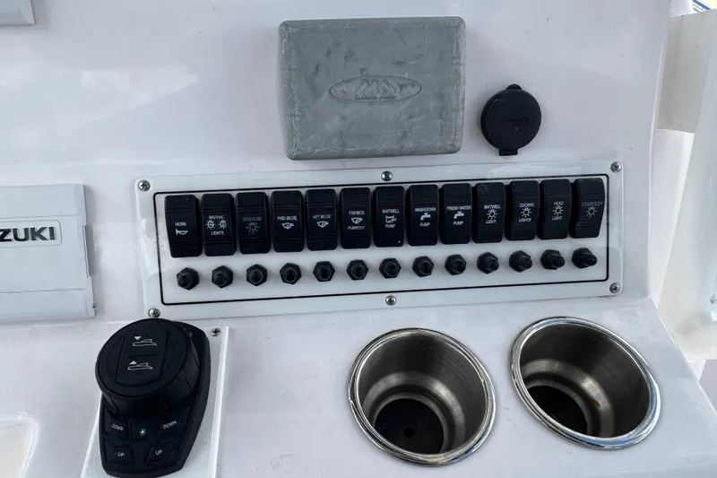 Slide: The Image of Control panel of a 2017 Pro-Line 26 Super Sport boat with switches and cup holders. - 13