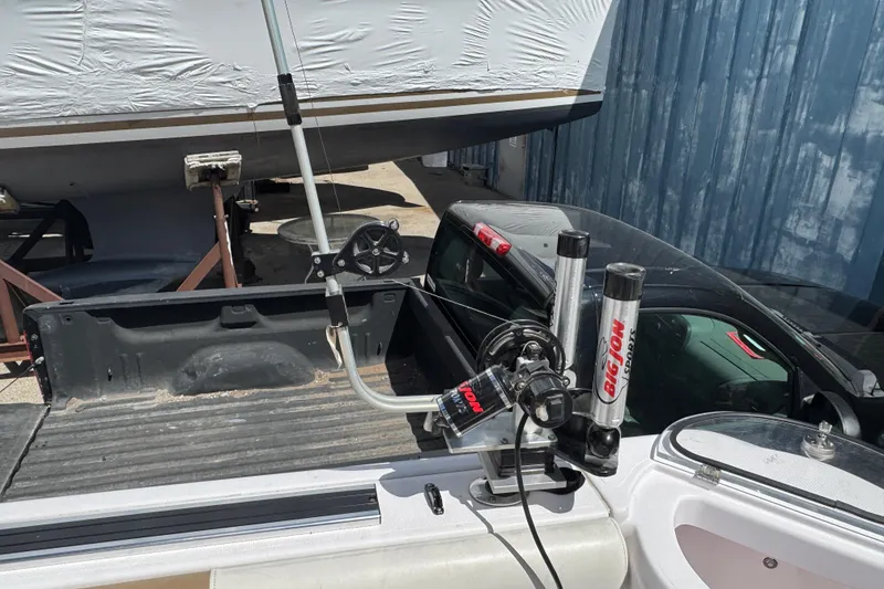 Slide: The Image of 2017 Pro-Line 26 Super Sport boat with fishing equipment, parked near a truck. - 18