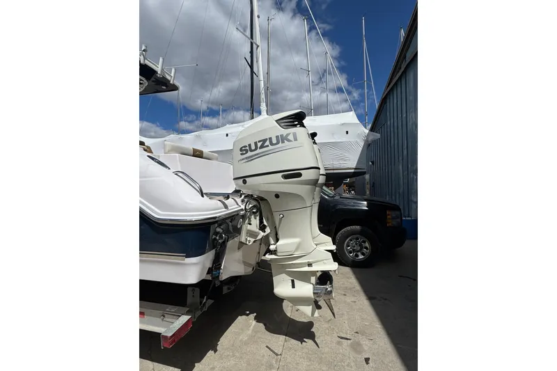 Slide: The Image of 2017 Pro-Line 26 Super Sport boat with Suzuki outboard motor in a marina setting. - 2