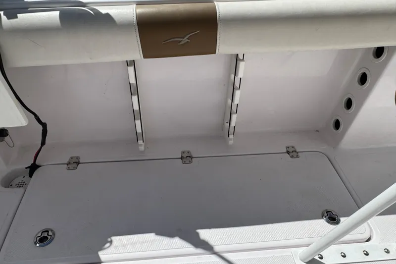 Slide: The Image of 2017 Pro-Line 26 Super Sport boat interior with storage compartment and rod holders. - 20