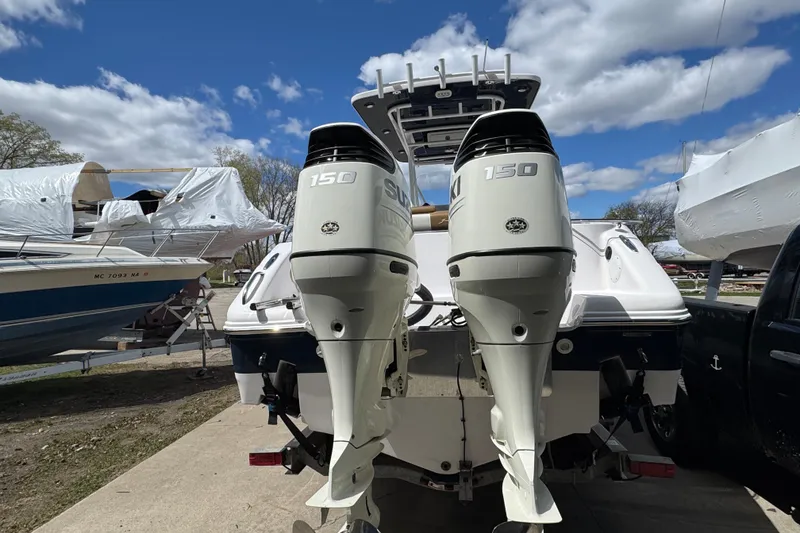 Slide: The Image of 2017 Pro-Line 26 Super Sport boat with dual Suzuki 150 outboard motors, parked outdoors. - 3
