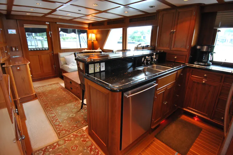 Slide: The Image of Luxurious 2002 Grand Alaskan Cockpit Motor Yacht interior with elegant wood cabinetry and modern kitchen amenities. - 15