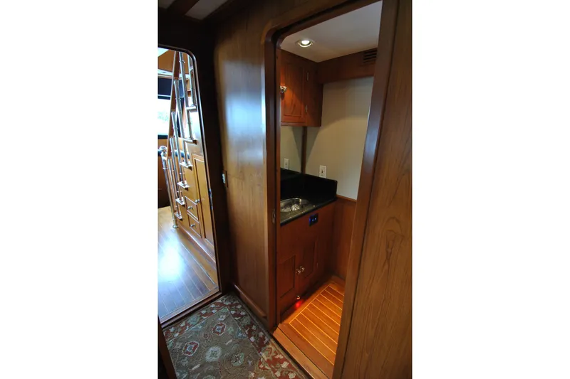 Slide: The Image of Interior of 2002 Grand Alaskan Cockpit Motor Yacht with wooden cabinetry and compact sink area. - 17