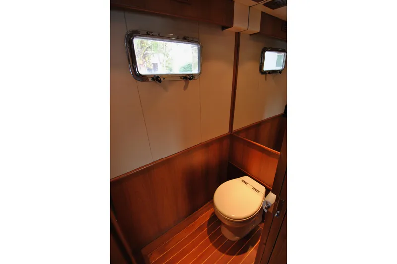 Slide: The Image of 2002 Grand Alaskan Cockpit Motor Yacht bathroom with wooden interior and porthole window. - 19