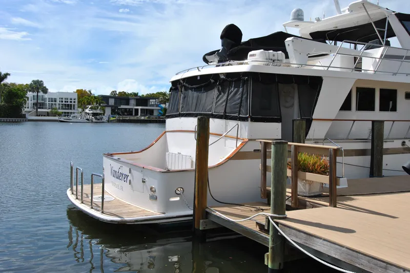 Slide: The Image of 2002 Grand Alaskan Cockpit Motor Yacht docked by waterfront homes. - 2