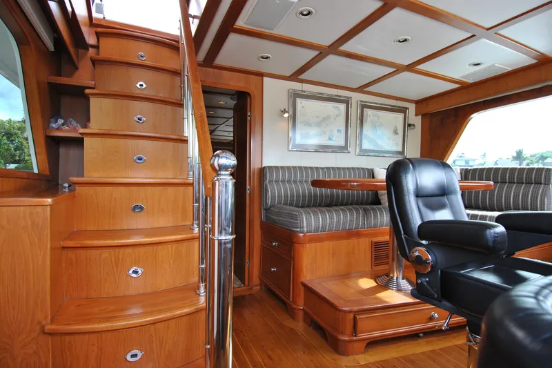 Slide: The Image of Luxurious interior of 2002 Grand Alaskan Cockpit Motor Yacht with wooden stairs and seating area. - 21