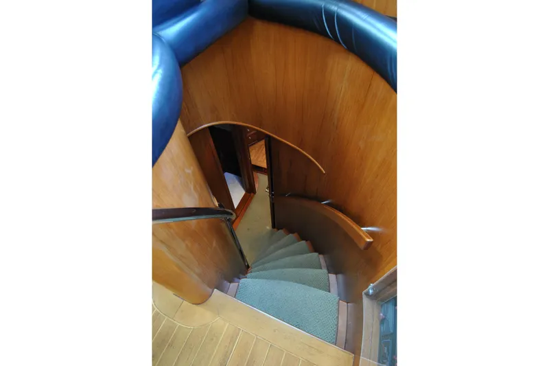 Slide: The Image of Interior staircase of 2002 Grand Alaskan Cockpit Motor Yacht, featuring elegant wood paneling. - 23