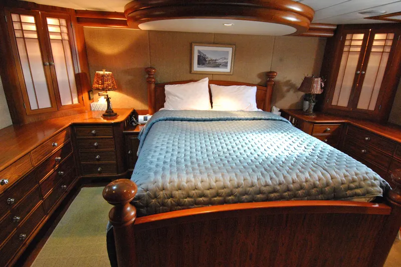 Slide: The Image of Luxurious bedroom interior of 2002 Grand Alaskan Cockpit Motor Yacht with elegant wood furnishings. - 25