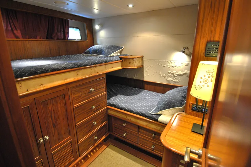Slide: The Image of Luxurious 2002 Grand Alaskan Cockpit Motor Yacht cabin with wooden furnishings and cozy bedding. - 32