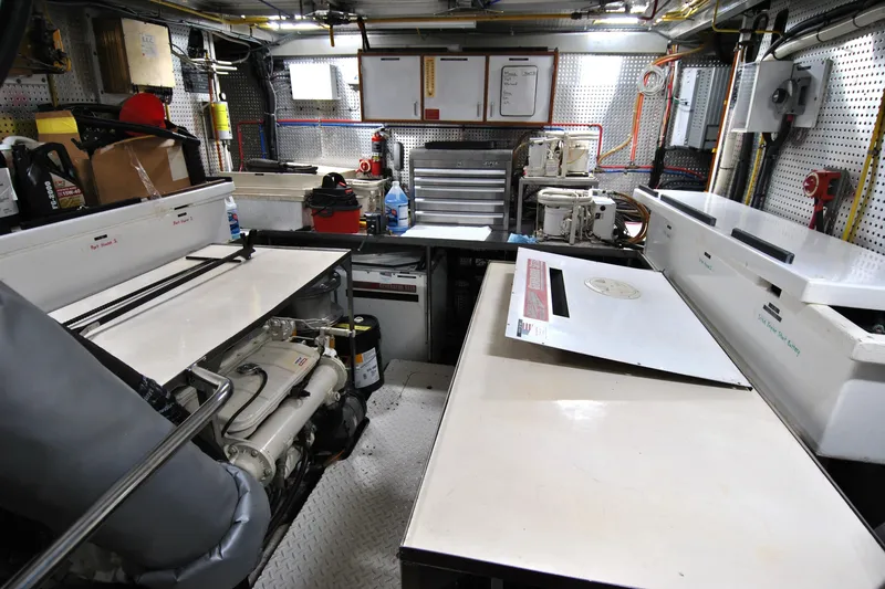 Slide: The Image of Engine room of a 2002 Grand Alaskan Cockpit Motor Yacht, featuring organized equipment and tools. - 36