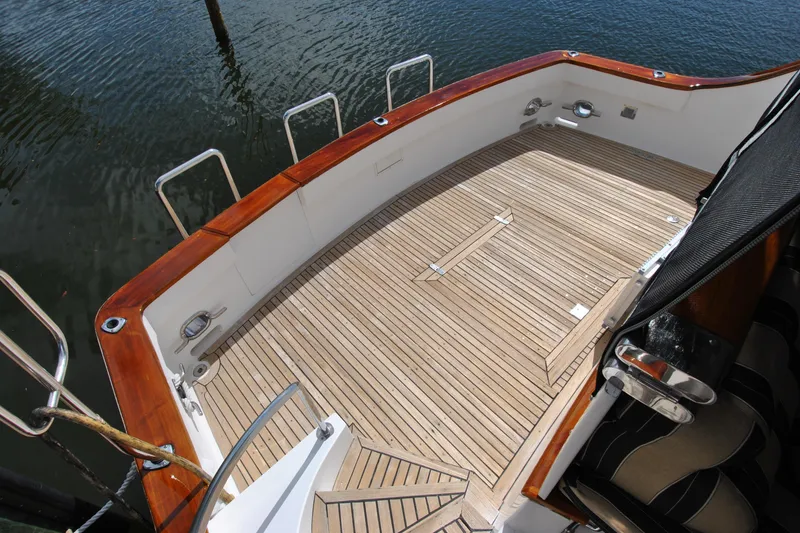 Slide: The Image of 2002 Grand Alaskan Cockpit Motor Yacht with teak deck, docked on calm water. - 4