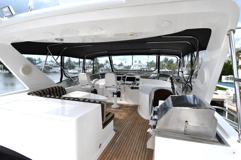 Slide: The Image of 2002 Grand Alaskan Cockpit Motor Yacht interior with seating, helm, and grill on deck. - 44