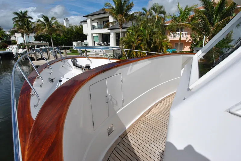 Slide: The Image of 2002 Grand Alaskan Cockpit Motor Yacht docked near waterfront homes, surrounded by palm trees. - 48