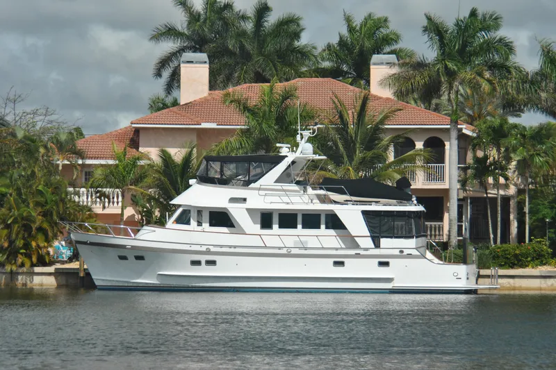 Slide: The Image of 2002 Grand Alaskan Cockpit Motor Yacht docked near a luxurious waterfront home. - 55