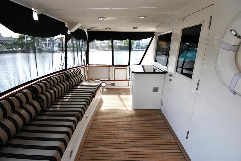 Slide: The Image of Luxurious 2002 Grand Alaskan Cockpit Motor Yacht interior with striped seating and wooden flooring. - 6