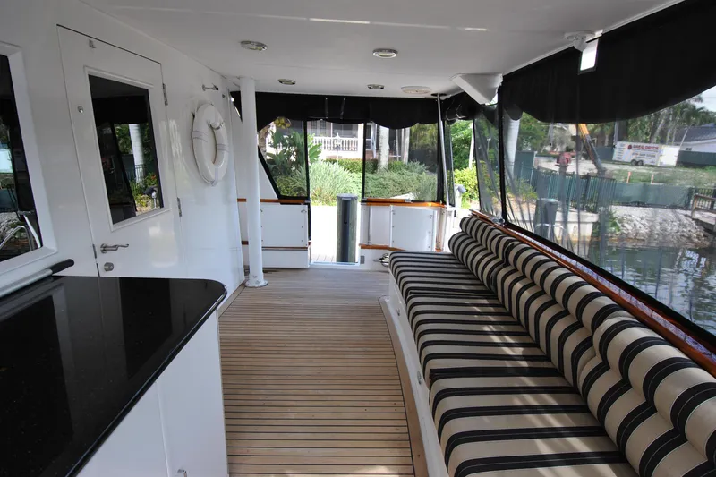 Slide: The Image of Spacious cockpit of 2002 Grand Alaskan Motor Yacht with striped seating and wooden flooring. - 7
