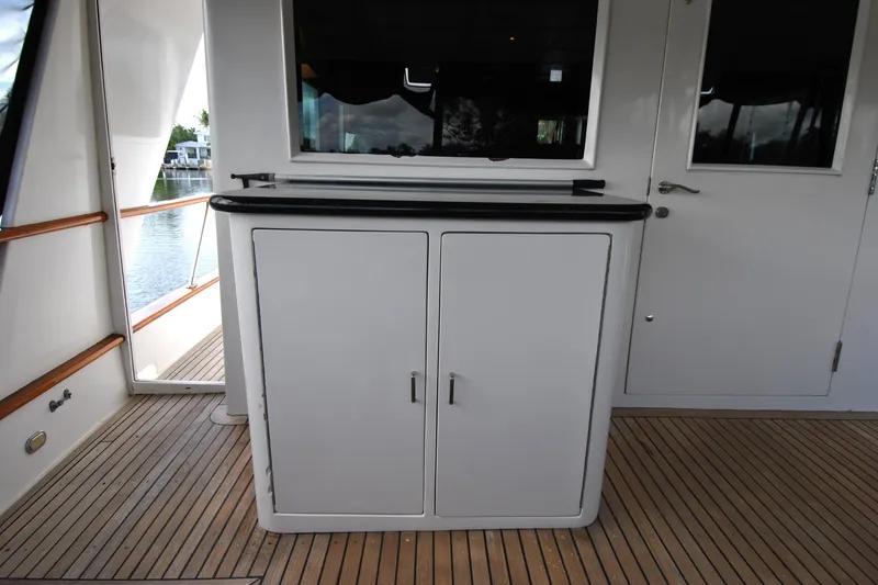Slide: The Image of Cockpit area of 2002 Grand Alaskan Motor Yacht with wooden flooring and storage cabinet. - 8