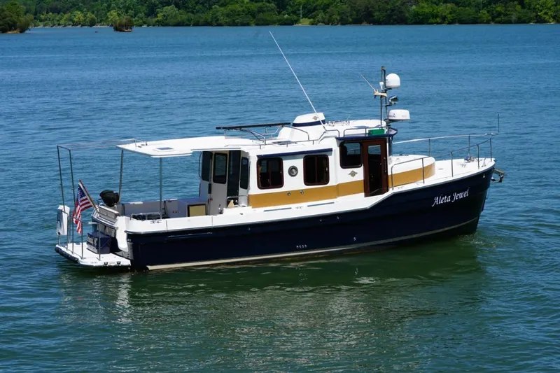 Slide: The Image of 2014 Ranger Tugs R-31 boat on calm water, featuring a sleek design and American flag. - 10