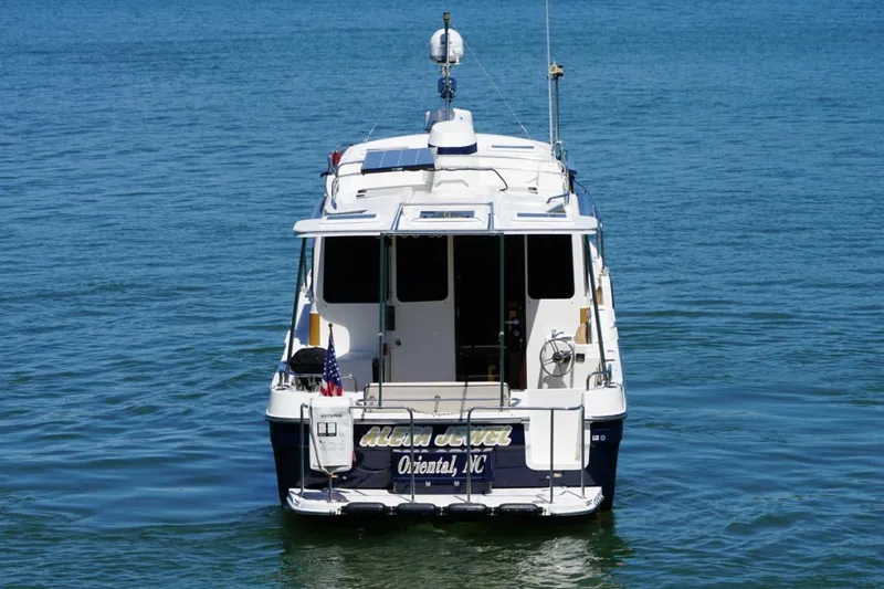 Slide: The Image of 2014 Ranger Tugs R-31 boat on calm water, rear view with American flag. - 11