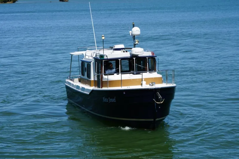 Slide: The Image of 2014 Ranger Tugs R-31 boat cruising on calm blue water. - 12