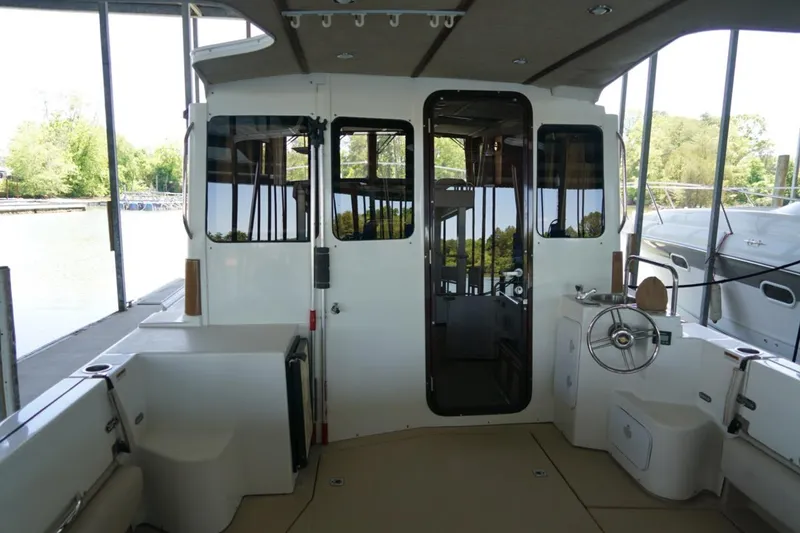 Slide: The Image of 2014 Ranger Tugs R-31 boat interior with helm, docked under a canopy. - 15