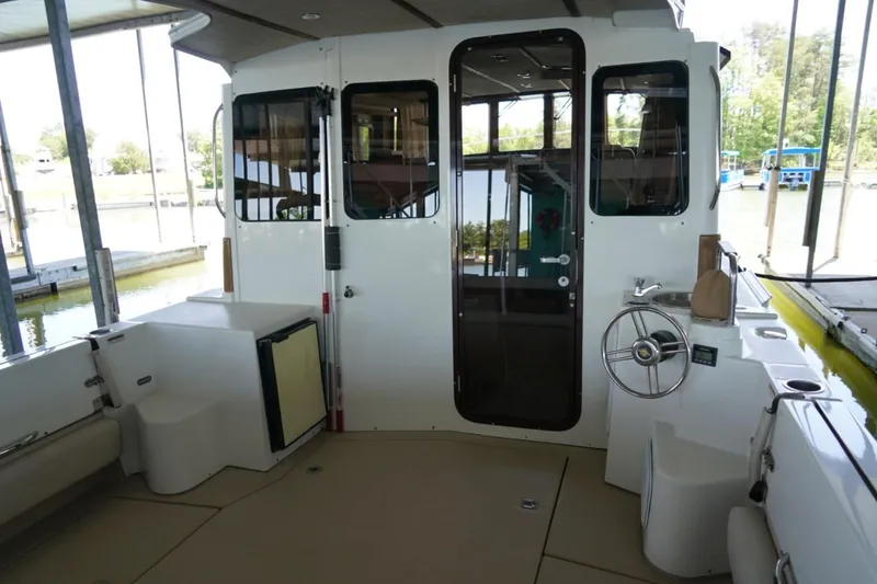 Slide: The Image of 2014 Ranger Tugs R-31 boat interior with helm, seating, and dockside view. - 16