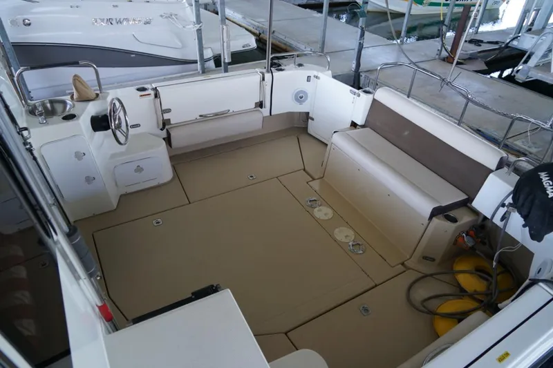 Slide: The Image of 2014 Ranger Tugs R-31 boat cockpit with seating and steering wheel in marina. - 17