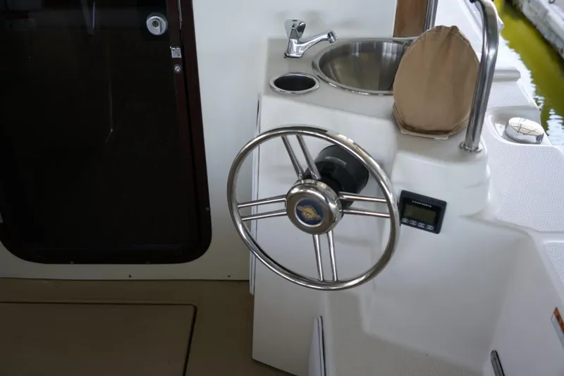 Slide: The Image of Steering wheel and sink on 2014 Ranger Tugs R-31 boat deck. - 18