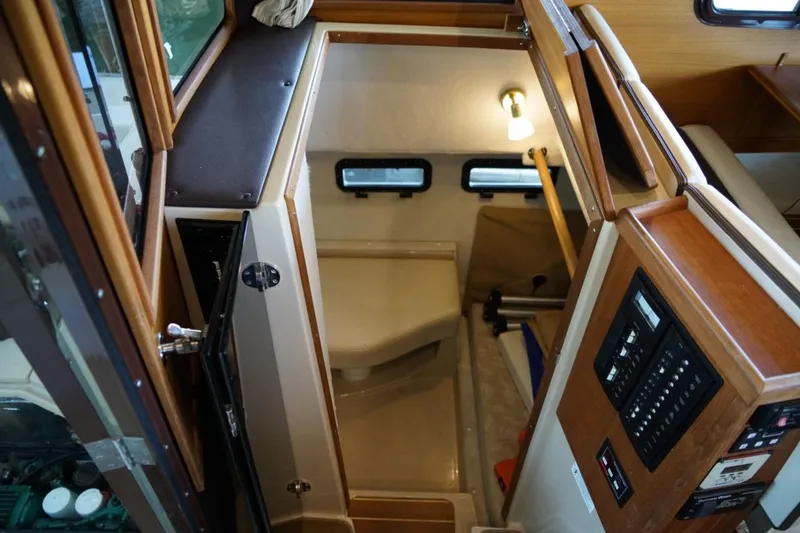 Slide: The Image of 2014 Ranger Tugs R-31 interior cabin with control panel and seating area. - 23