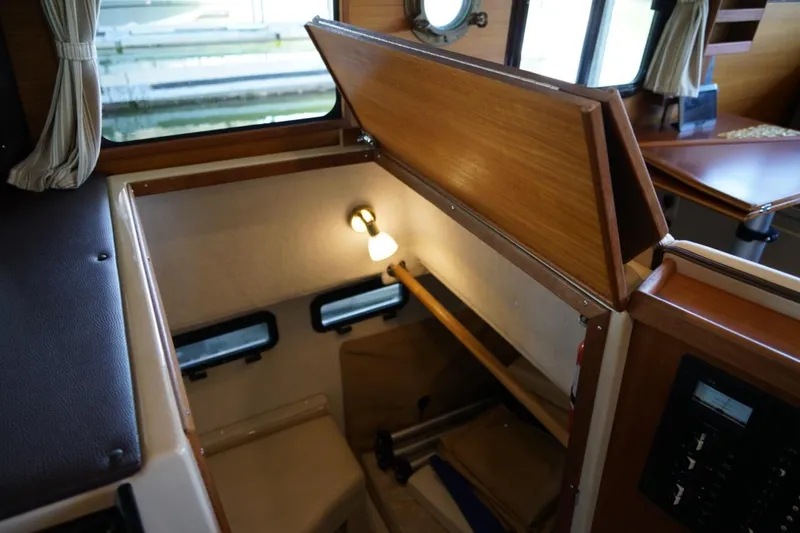 Slide: The Image of 2014 Ranger Tugs R-31 interior cabin with wooden finish and cozy lighting. - 24