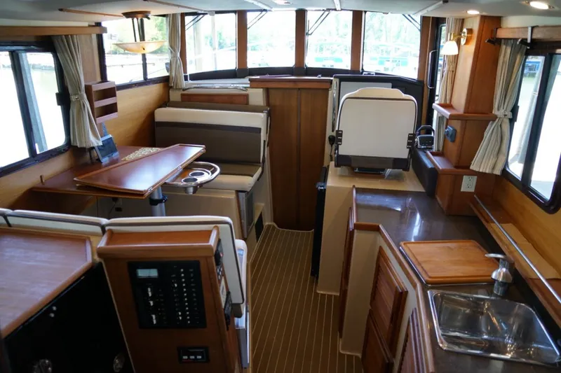 Slide: The Image of Interior of 2014 Ranger Tugs R-31 boat, featuring seating, table, and kitchenette. - 27