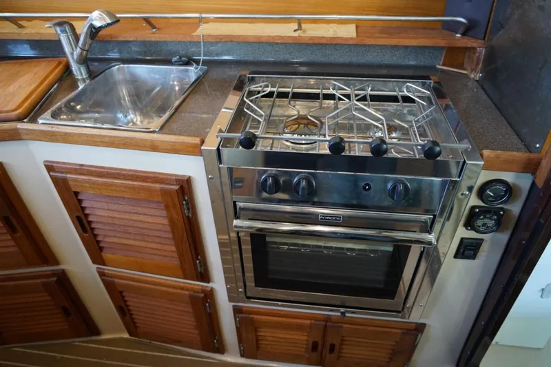 Slide: The Image of 2014 Ranger Tugs R-31 galley with stainless steel stove, oven, and sink. - 29