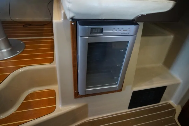 Slide: The Image of 2014 Ranger Tugs R-31 interior with built-in Dometic fridge and wooden flooring. - 31