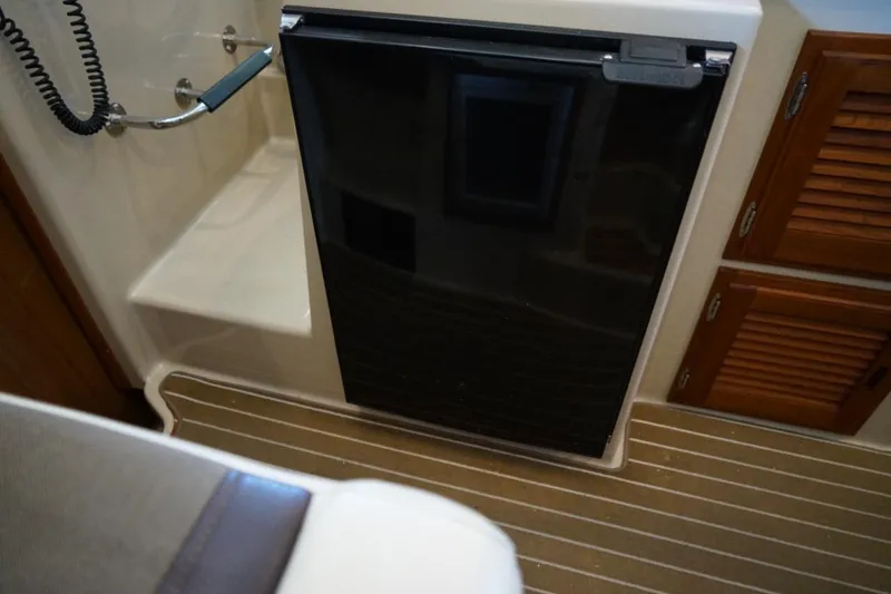 Slide: The Image of Interior of 2014 Ranger Tugs R-31 with fridge and wooden cabinets. - 32