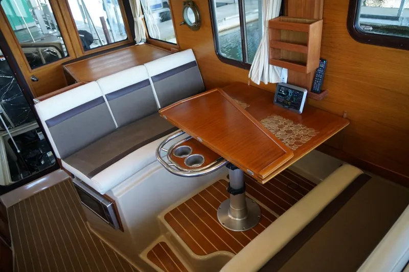 Slide: The Image of Interior of 2014 Ranger Tugs R-31 with wooden table and seating area. - 35