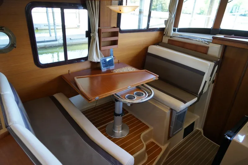 Slide: The Image of Interior of 2014 Ranger Tugs R-31 with cozy dining area and wooden accents. - 38