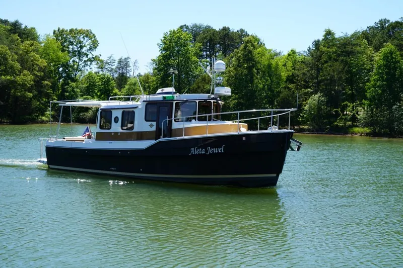 Slide: The Image of 2014 Ranger Tugs R-31 boat cruising on a serene lake surrounded by lush greenery. - 4