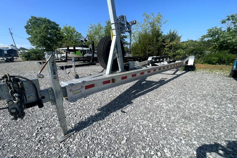 Slide: The Image of Trailer for 2014 Ranger Tugs R-31 S on gravel lot, surrounded by trees. - 46