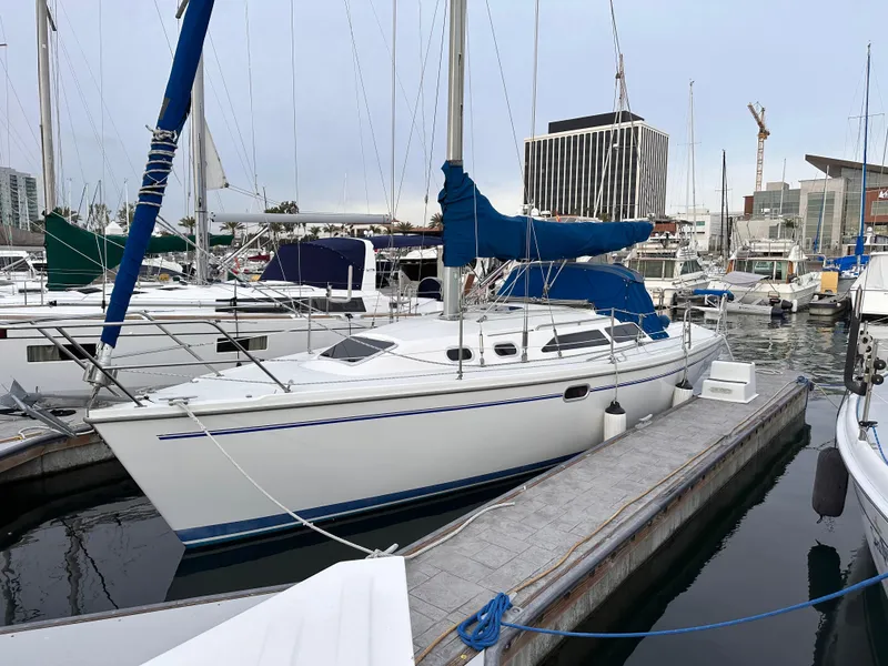 The Image of Catalina 320 sailboat, 2000 model, docked in a marina with other boats. - 0