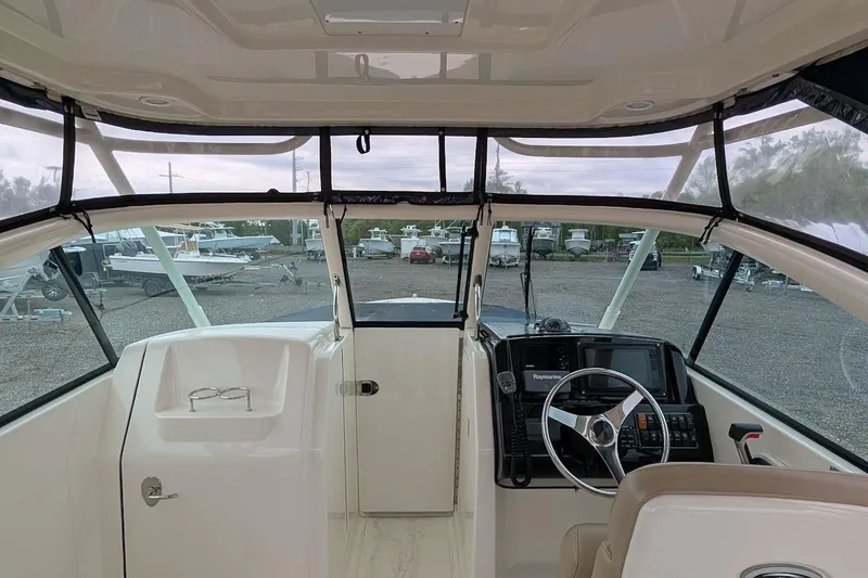 Slide: The Image of Interior view of a 2011 Pursuit DC 265 Dual Console boat, showcasing the helm and dashboard. - 15