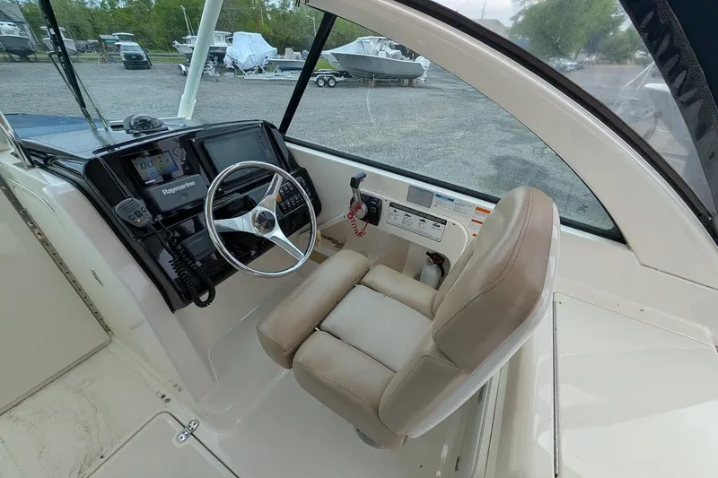 Slide: The Image of 2011 Pursuit DC 265 Dual Console boat cockpit with steering wheel and navigation equipment. - 20
