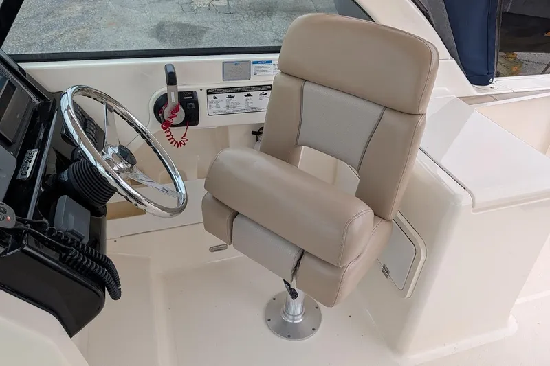 Slide: The Image of Captain's seat and steering wheel of 2011 Pursuit DC 265 Dual Console boat. - 21