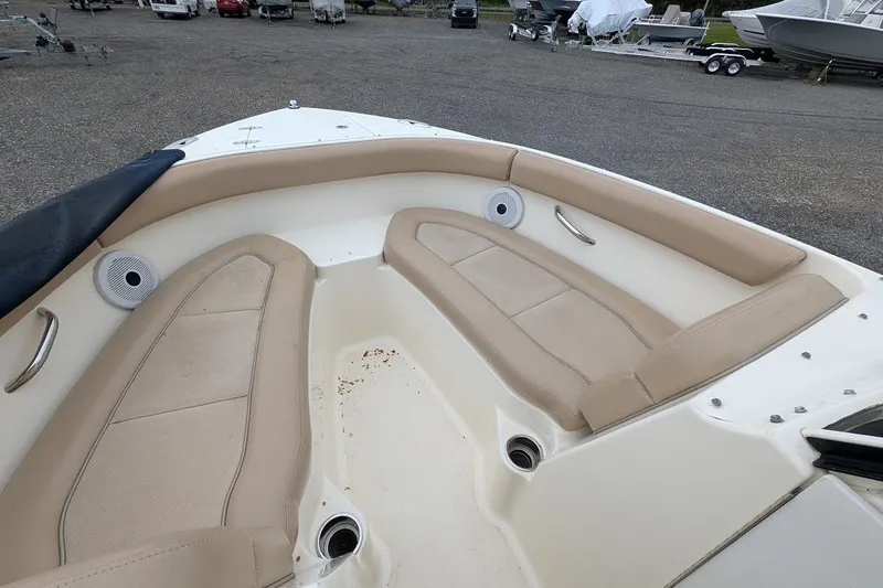 Slide: The Image of 2011 Pursuit DC 265 Dual Console boat interior with beige seating and speakers. - 28