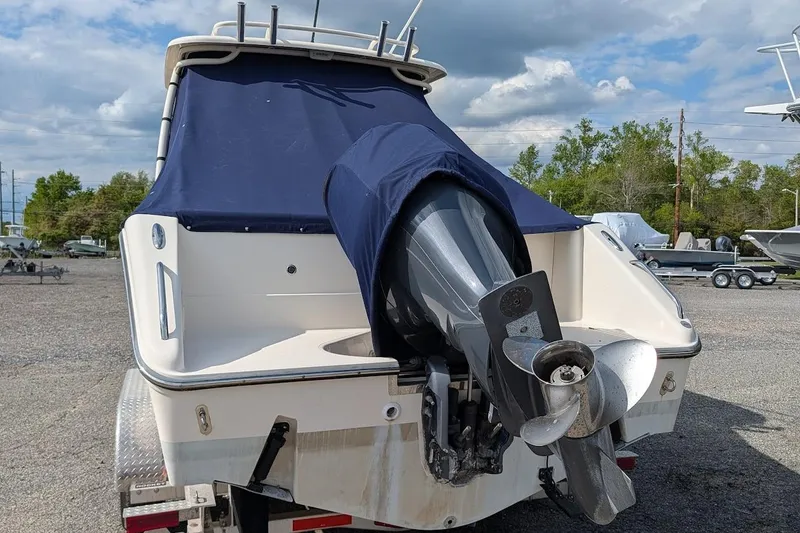 Slide: The Image of 2011 Pursuit DC 265 Dual Console boat with covered outboard motor, parked outdoors. - 5