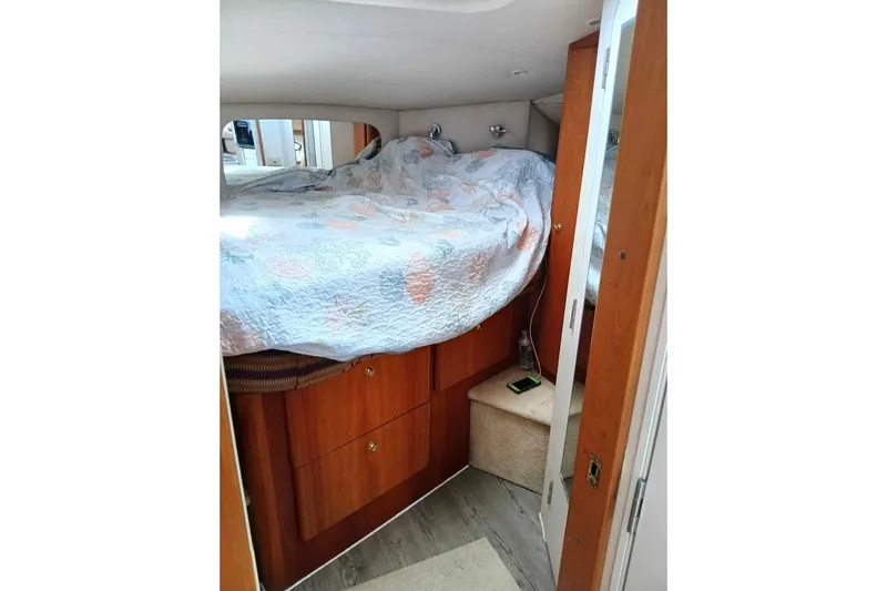 Slide: The Image of Cozy bedroom interior of 2000 Silverton 422 Motor Yacht with wooden cabinetry. - 10