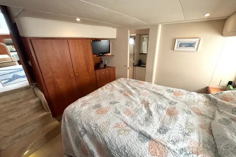 Slide: The Image of Interior of 2000 Silverton 422 Motor Yacht with cozy bedroom and wooden cabinetry. - 43