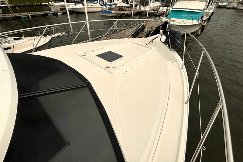 Slide: The Image of 2000 Silverton 422 Motor Yacht docked at marina, showcasing spacious deck and sleek design. - 12