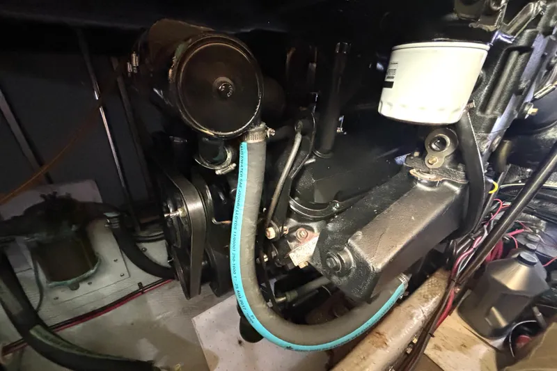 Slide: The Image of Engine compartment of a 2000 Silverton 422 Motor Yacht, showcasing mechanical components and hoses. - 54