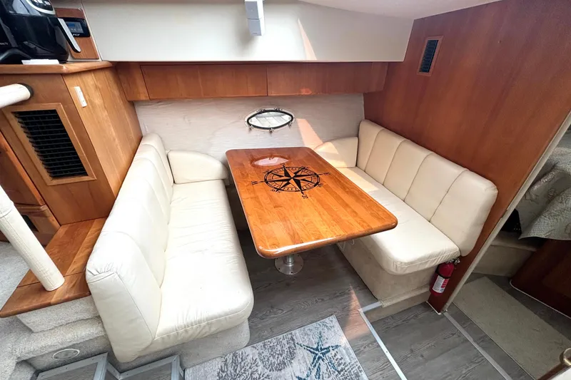 Slide: The Image of Interior of 2000 Silverton 422 Motor Yacht with cozy dining area and wooden table. - 38