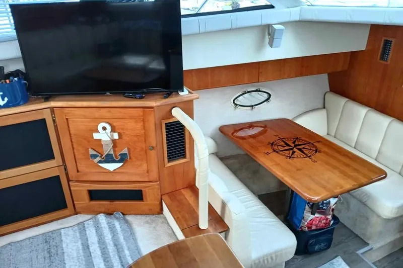 Slide: The Image of Interior of 2000 Silverton 422 Motor Yacht with TV, anchor decor, and compass table. - 7